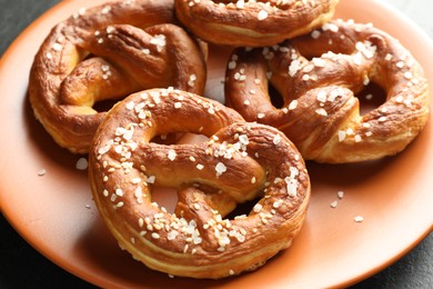 Photo of Tasty pretzels with salt on table, closeup