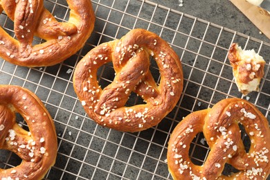 Photo of Tasty pretzels with salt on grey table, top view