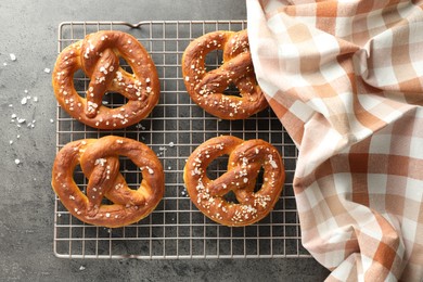 Photo of Tasty pretzels with salt on grey table, top view