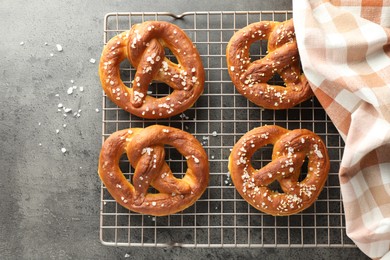 Photo of Tasty pretzels with salt on grey table, top view