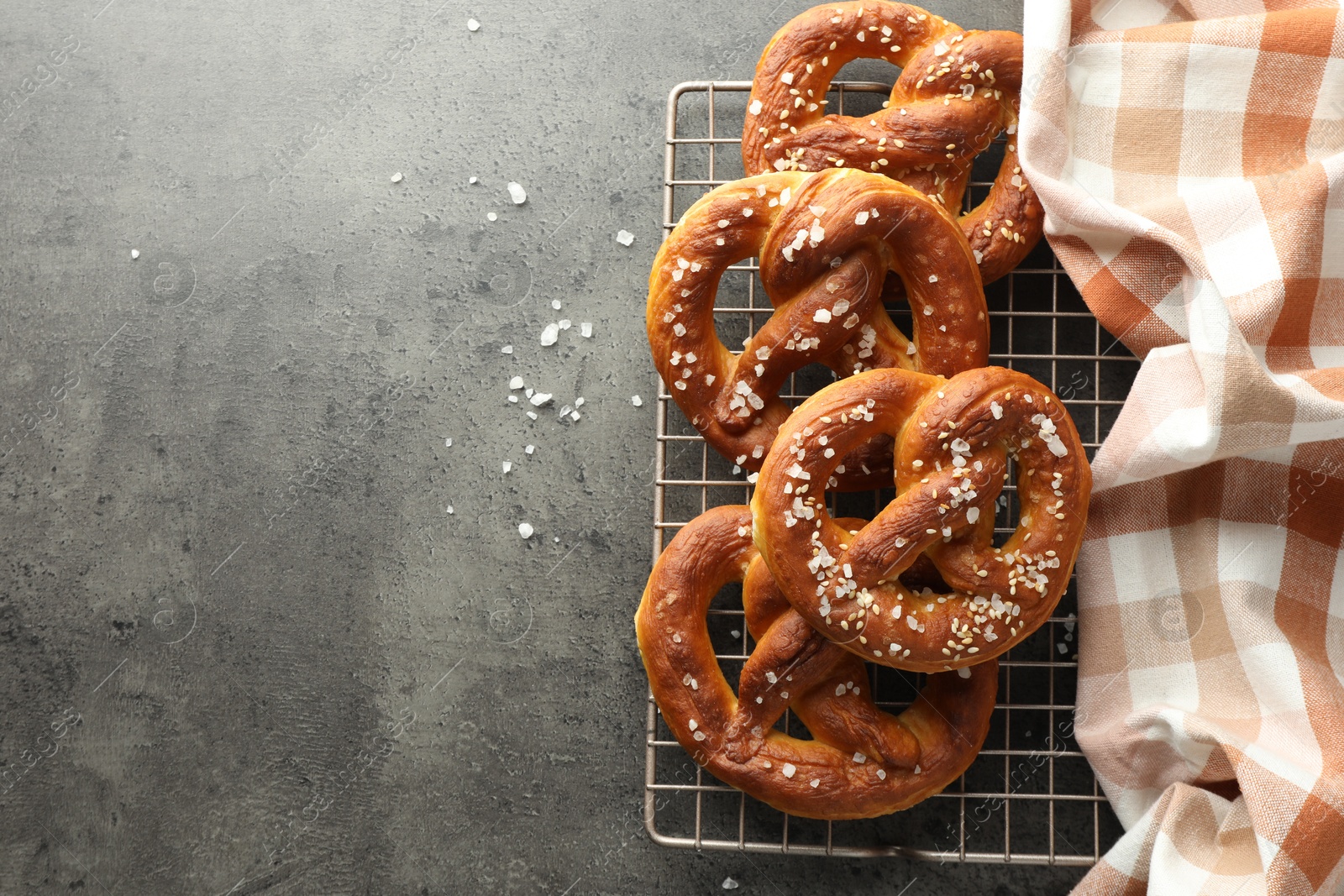 Tasty pretzels with salt on grey table, top view. Space for text Photo of Tasty pretzels with salt on grey table, top view. Space for text