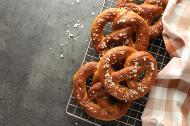 Photo of Tasty pretzels with salt on grey table, top view. Space for text