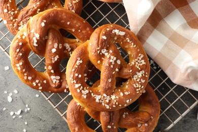Photo of Tasty pretzels with salt on grey table, top view