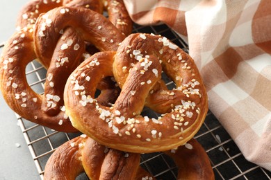 Photo of Tasty pretzels with salt on grey table, above view