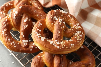 Photo of Tasty pretzels with salt on grey table, above view
