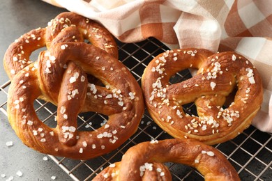 Photo of Tasty pretzels with salt on grey table, above view