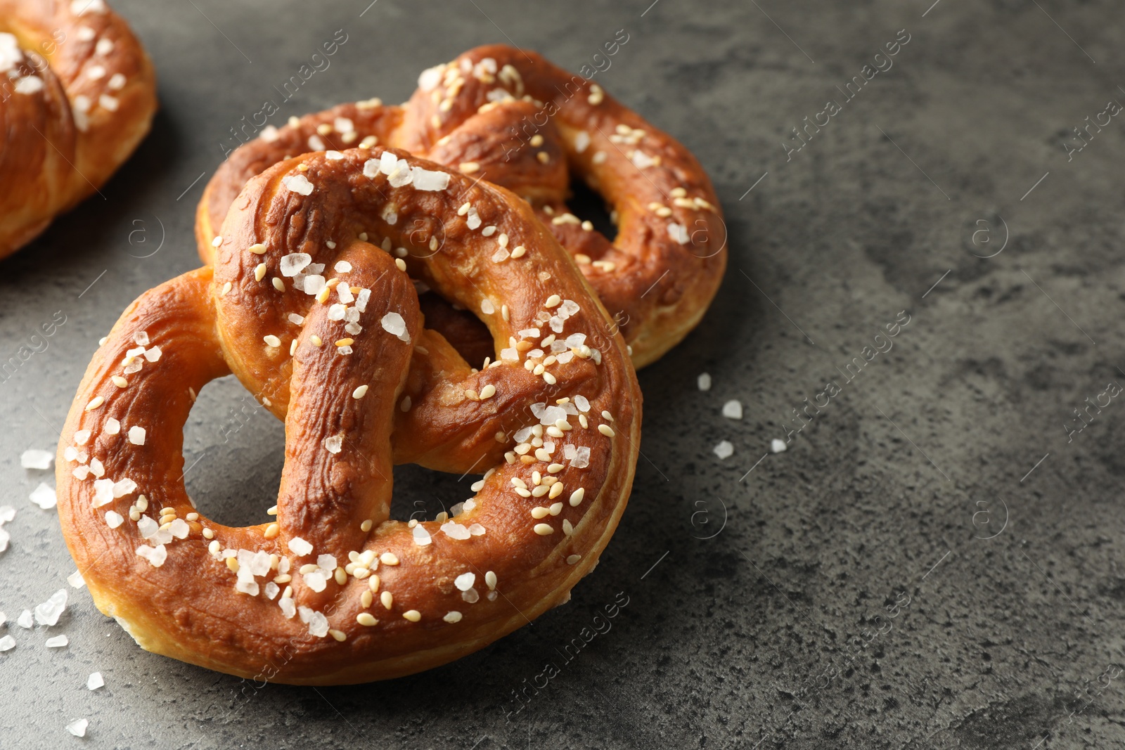 Tasty pretzels with salt on grey table, closeup. Space for text Photo of Tasty pretzels with salt on grey table, closeup. Space for text