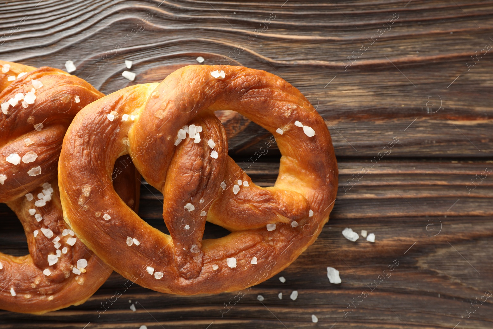 Tasty pretzels with salt on wooden table, flat lay. Space for text Photo of Tasty pretzels with salt on wooden table, flat lay. Space for text