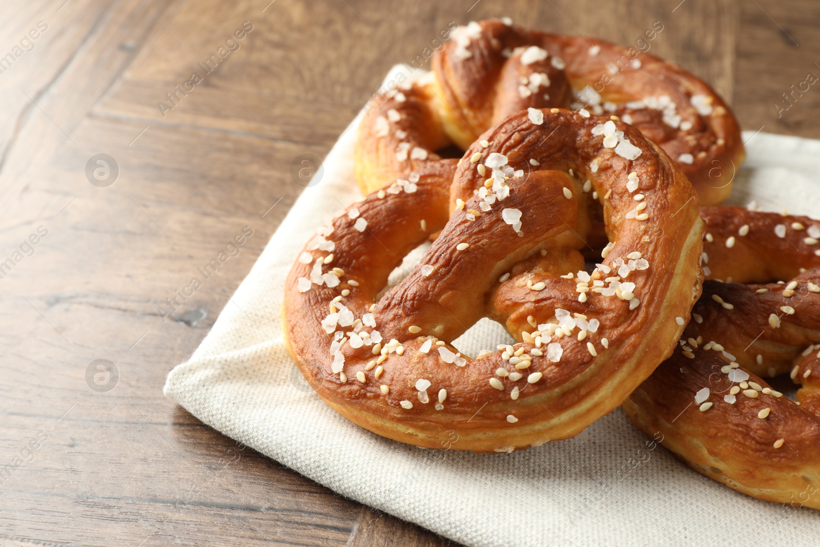 Tasty pretzels with salt on wooden table, closeup. Space for text Photo of Tasty pretzels with salt on wooden table, closeup. Space for text