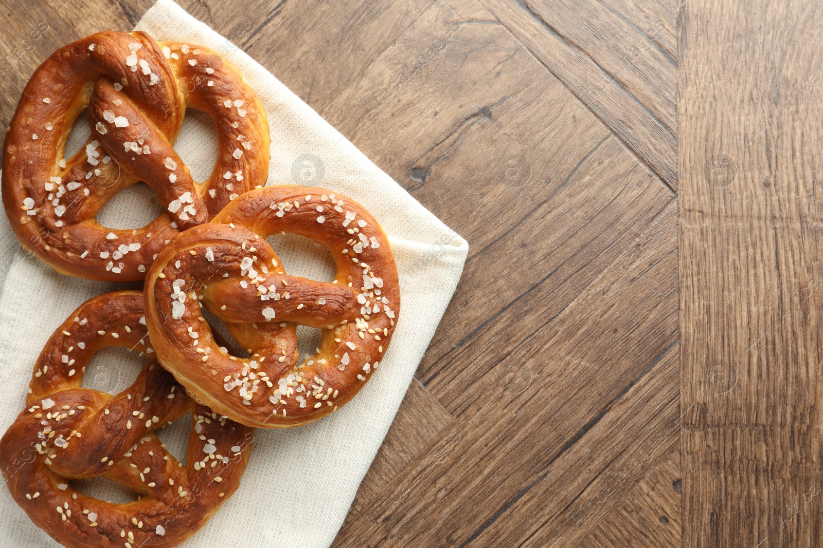Tasty pretzels with salt on wooden table, flat lay. Space for text Photo of Tasty pretzels with salt on wooden table, flat lay. Space for text