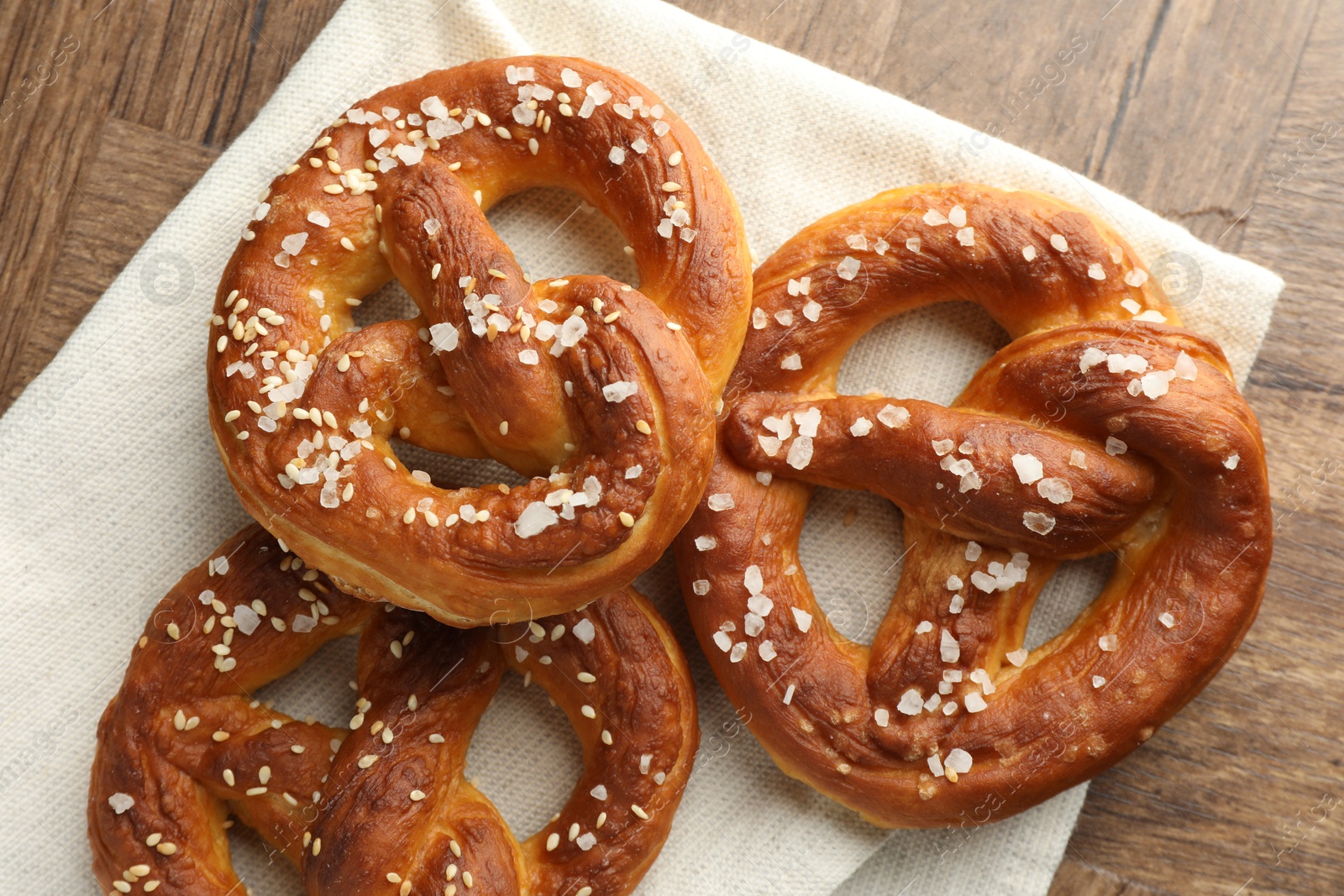 Tasty pretzels with salt on wooden table, flat lay Photo of Tasty pretzels with salt on wooden table, flat lay