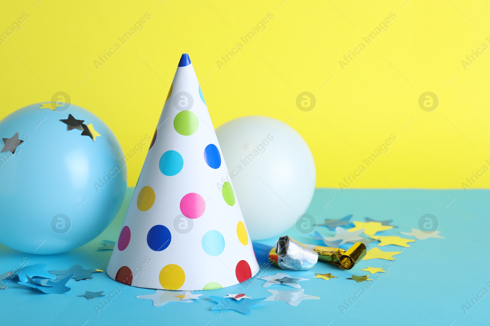 Beautiful party hat and other festive decor on color background, space for text Photo of Beautiful party hat and other festive decor on color background, space for text