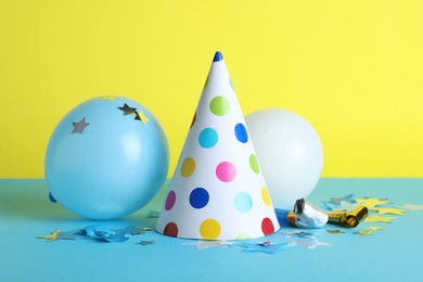 Photo of Beautiful party hat and other festive decor on color background