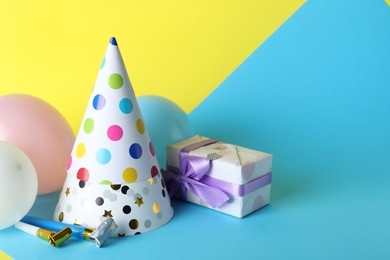 Photo of Beautiful party hats and other festive decor on color background, space for text