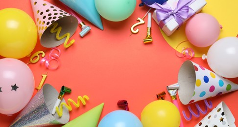 Photo of Beautiful party hats and other festive decor on red background, flat lay. Space for text