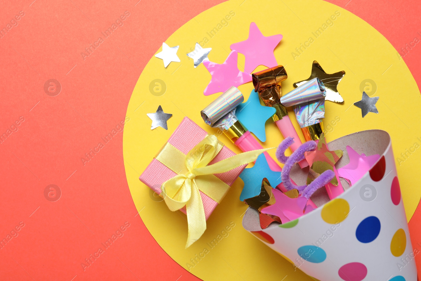 Beautiful party hat and other festive decor on red background, flat lay. Space for text Photo of Beautiful party hat and other festive decor on red background, flat lay. Space for text