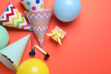 Photo of Beautiful party hats and other festive decor on red background, flat lay. Space for text