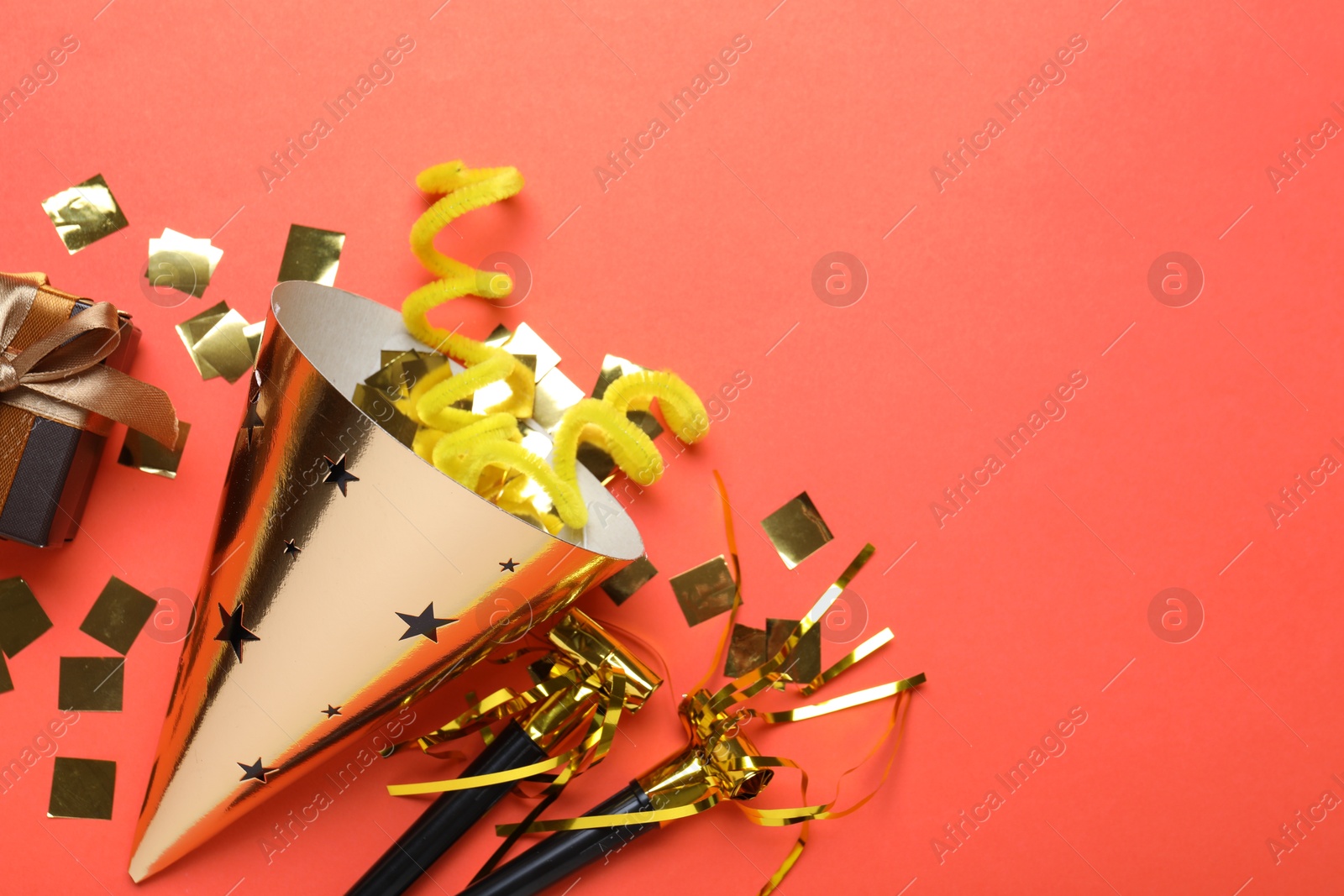 Beautiful party hat and other festive decor on red background, flat lay. Space for text Photo of Beautiful party hat and other festive decor on red background, flat lay. Space for text