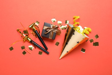 Photo of Beautiful party hat and other festive decor on red background, flat lay