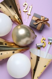 Photo of Beautiful party hats and other festive decor on violet background, flat lay