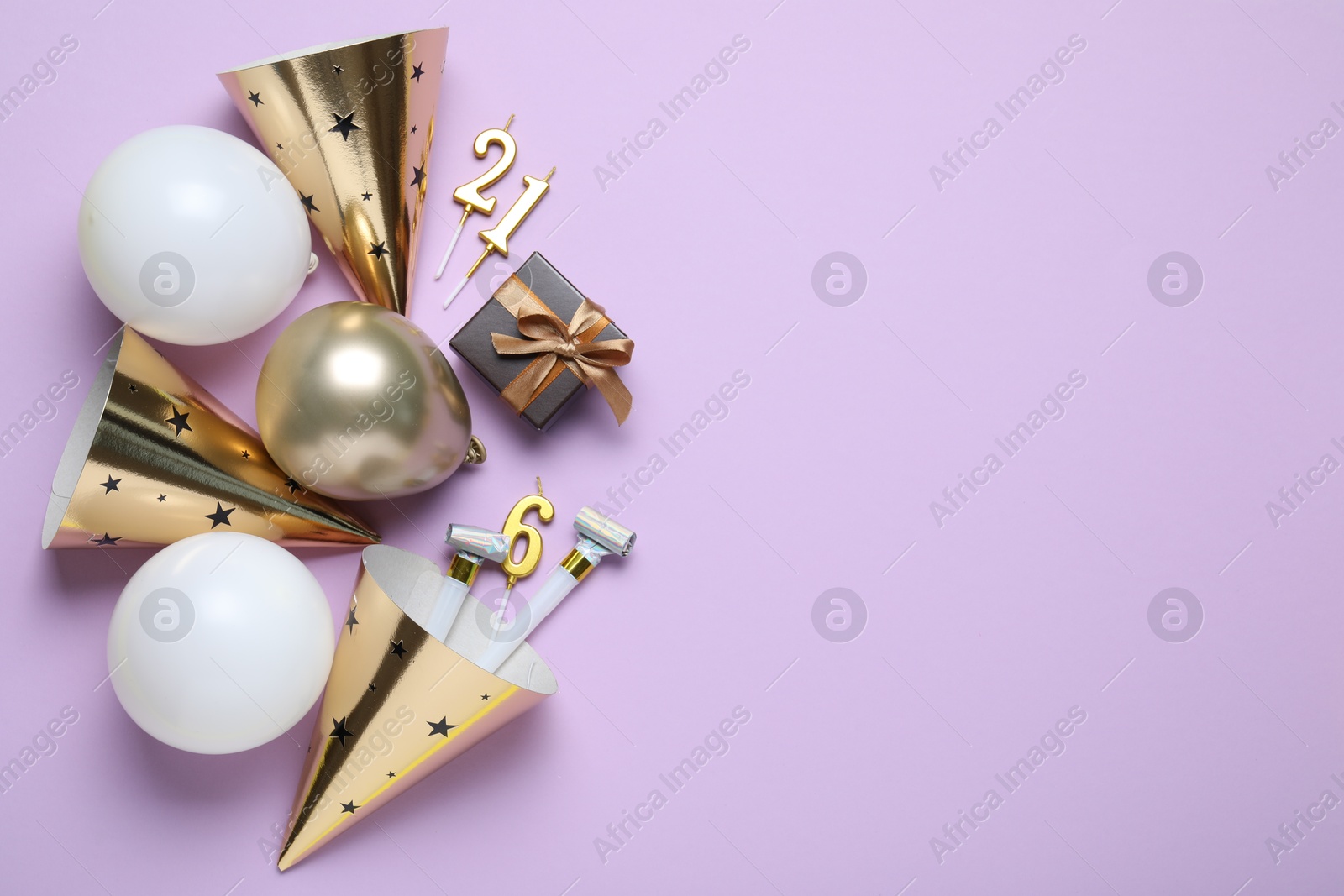 Beautiful party hats and other festive decor on violet background, flat lay. Space for text Photo of Beautiful party hats and other festive decor on violet background, flat lay. Space for text