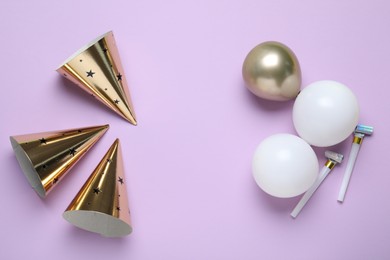 Photo of Beautiful party hats and other festive decor on violet background, flat lay. Space for text