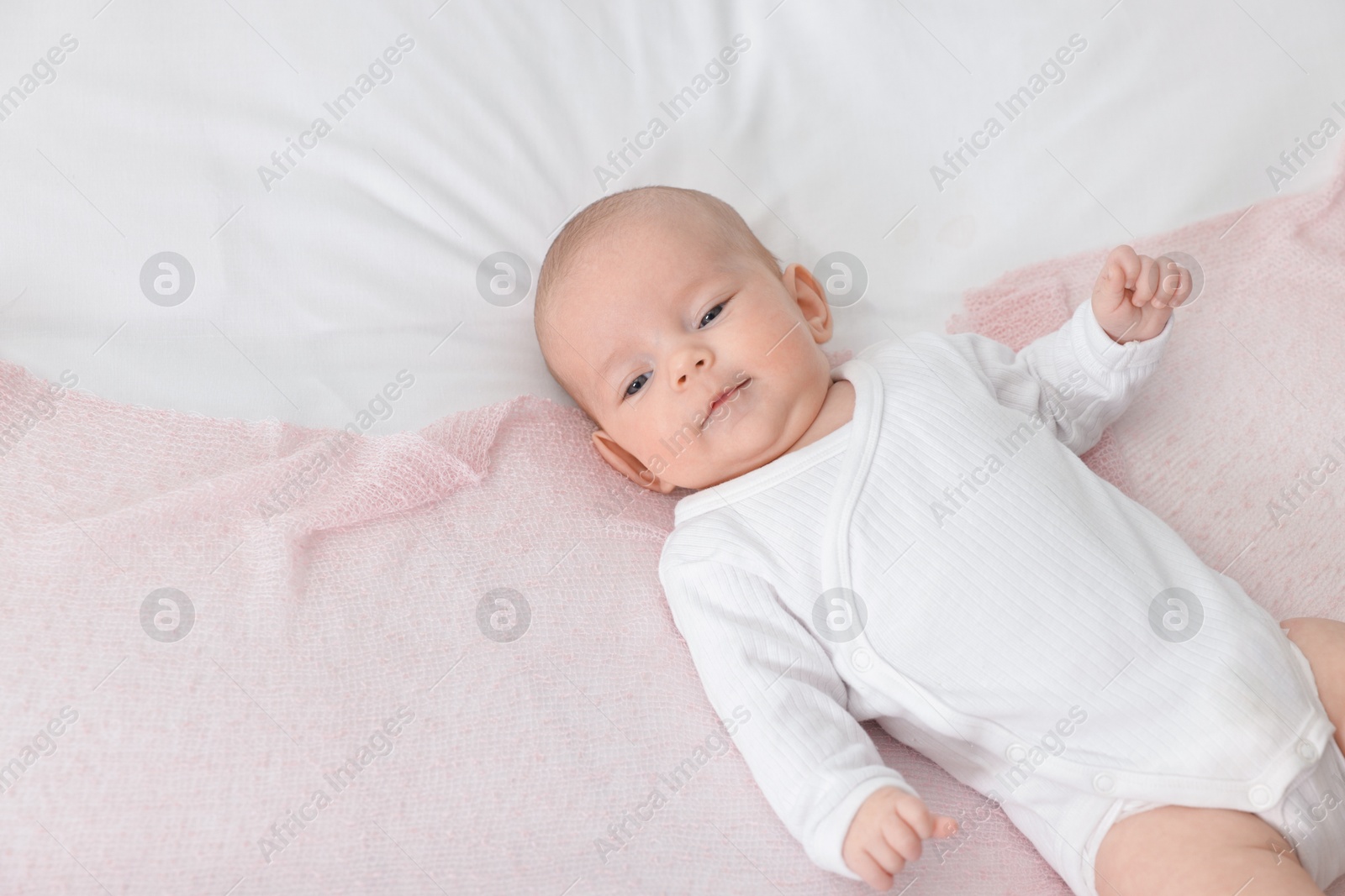 Cute little baby lying on bed at home, top view. Space for text Photo of Cute little baby lying on bed at home, top view. Space for text