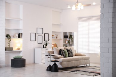 Photo of Comfortable sofa with cushions in room. Interior design