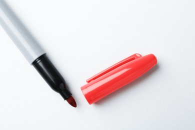 Photo of One red marker on light background, top view