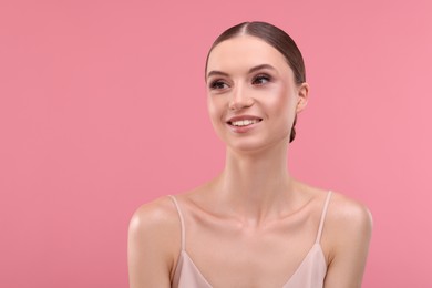 Photo of Portrait of beautiful young woman on pink background