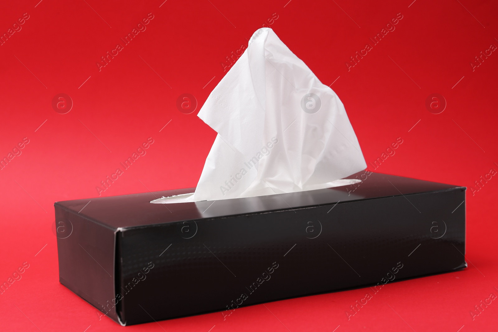 Box with paper handkerchiefs on red background, closeup Photo of Box with paper handkerchiefs on red background, closeup