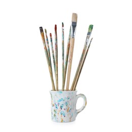 Photo of Brushes with color paints in cup isolated on white