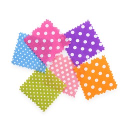 Photo of Samples of fabrics with polka dot pattern isolated on white, top view