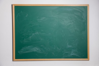 Photo of Blank green chalkboard on wall, space for text
