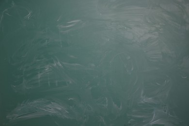 Photo of Chalk rubbed out on green chalkboard as background, closeup. Space for text