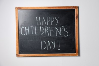 Photo of Phrase Happy Children’s Day with exclamation mark on blackboard