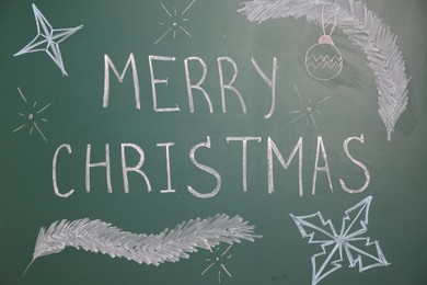 Photo of Phrase Merry Christmas and different drawings on green chalkboard