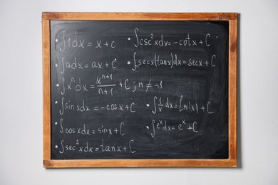 Photo of Blackboard with different mathematical formulas on white wall