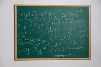 Photo of Green chalkboard with different mathematical formulas on wall