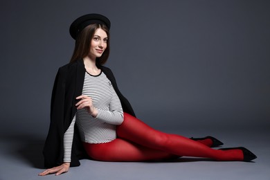 Photo of Fashionable portrait of beautiful woman in stylish outfit on grey background. Space for text