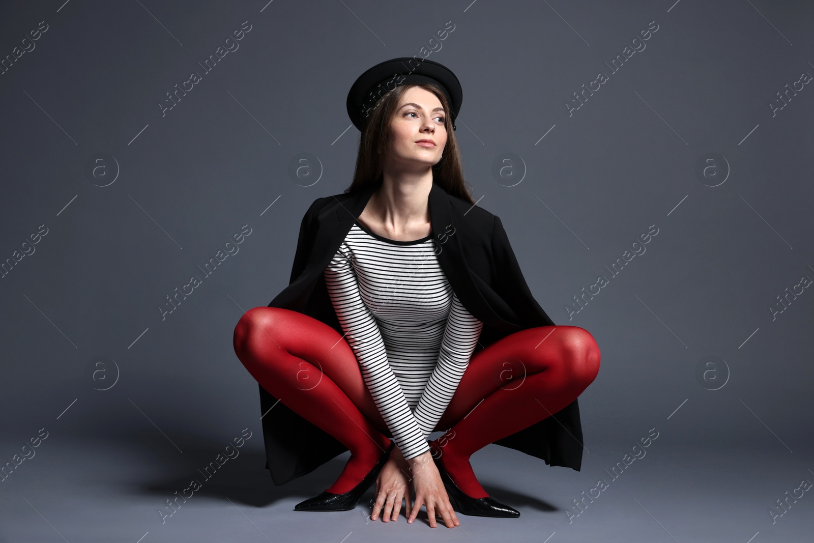 Fashionable portrait of beautiful woman in stylish outfit on grey background Photo of Fashionable portrait of beautiful woman in stylish outfit on grey background