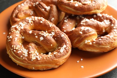 Photo of Tasty pretzels with salt on table, closeup
