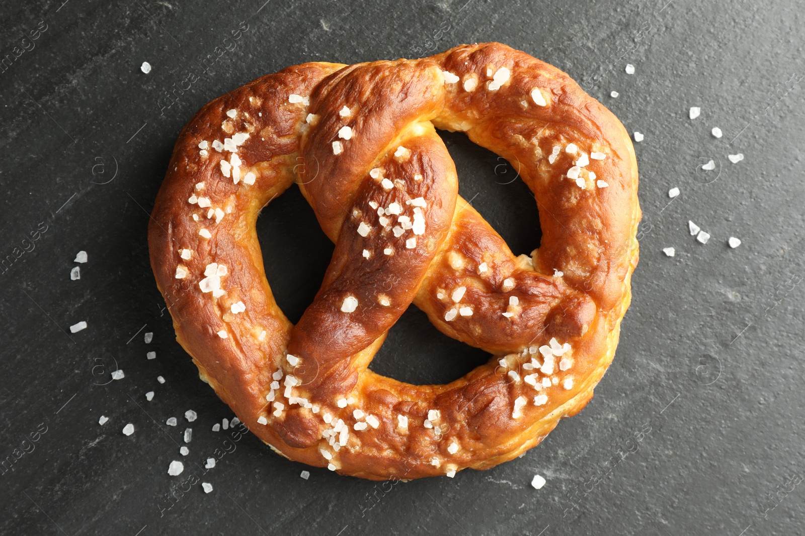 Tasty pretzel with salt on black table, top view Photo of Tasty pretzel with salt on black table, top view