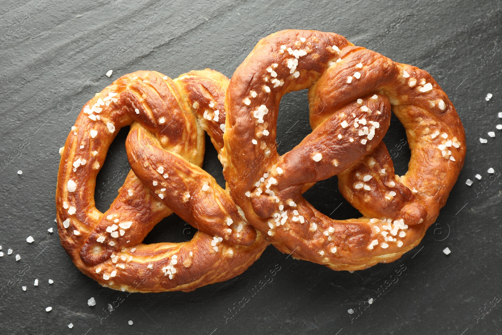 Tasty pretzels with salt on black table, flat lay Photo of Tasty pretzels with salt on black table, flat lay