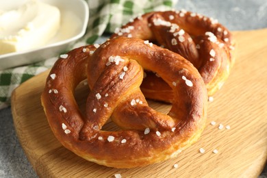 Photo of Tasty pretzels with salt and butter on table, closeup