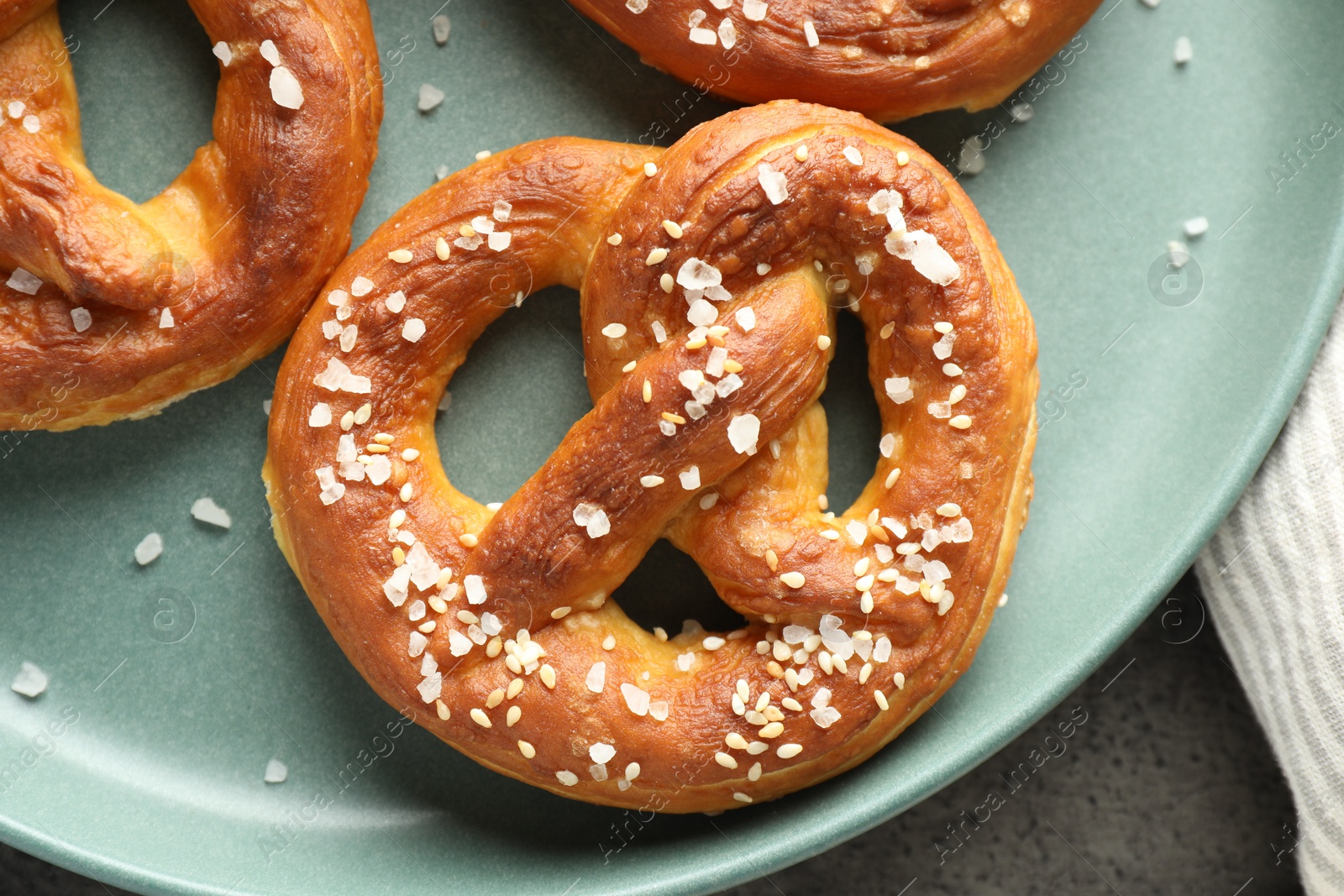Tasty pretzels with salt on grey table, top view Photo of Tasty pretzels with salt on grey table, top view