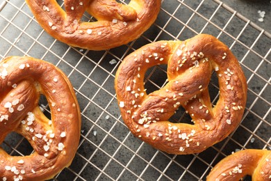 Photo of Tasty pretzels with salt on grey table, top view