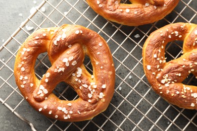 Photo of Tasty pretzels with salt on grey table, top view