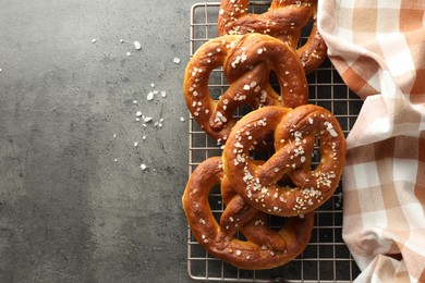 Photo of Tasty pretzels with salt on grey table, top view. Space for text