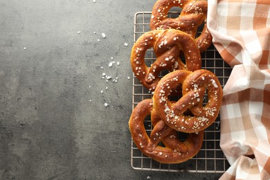 Photo of Tasty pretzels with salt on grey table, top view. Space for text
